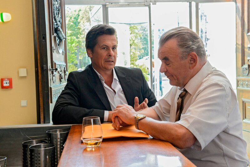 „Vorstadtweiber“, „(9).“ Josef Steinberg ist erschossen worden. Am Tatort verhört Kriminalinspektor Jörg Pudschedl die frisch gebackene Witwe und verhaftet sie sogleich, als er intime Fotos von Josef und Nicoletta in ihrem Auto findet. Bald ist sie wieder auf freiem Fuß und der nächste Tatverdächtige wird inhaftiert. Beim Toten hat man ein Umweltverträglichkeitsgutachten gefunden. Nervosität macht sich nicht nur bei unseren Grundstücksspekulanten, sondern bis in die hohe Politik hinein breit. Bei Josefs Testamentseröffnung erfährt Maria, wer wirklich der Vater von Waltrauds Kind ist.Im Bild (v.li.): Michael Dangl (Dieter West), Branko Samarovski (Bruno Pudschedl). – Bild: ARD/​ORF/​MR Film/​Hubert Mican