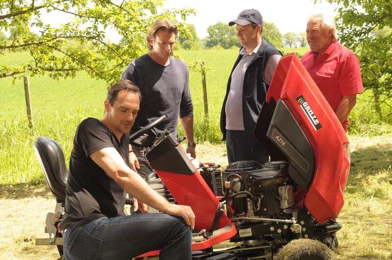 Hubert und Martin sind gespannt, wer den Mähwettbewerb gewinnt. Von links: Mike Preissinger (Harry Blank), Sebastian Wildner (Herbert Ulrich), Hubert Kirchleitner (Bernhard Ulrich) und Martin Kirchleitner (Hermann Giefer). – Bild: BR/​Jo Bischoff