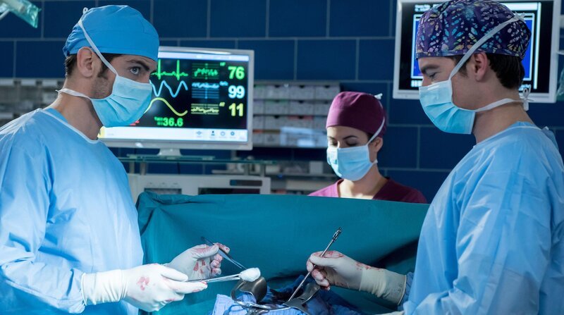 Die Ärzte Dr. Niklas Ahrend (Roy Peter Link, l.) und Ben Ahlbeck (Philipp Danne, r.) operieren Philipps Zwerchfell, er leidet am Dunbar-Syndrom. Dr. Leyla Sherbaz (Sanam Afrashteh, M.) überwacht Philipps Vitalfunktionen. – Bild: Jens-Ulrich Koch