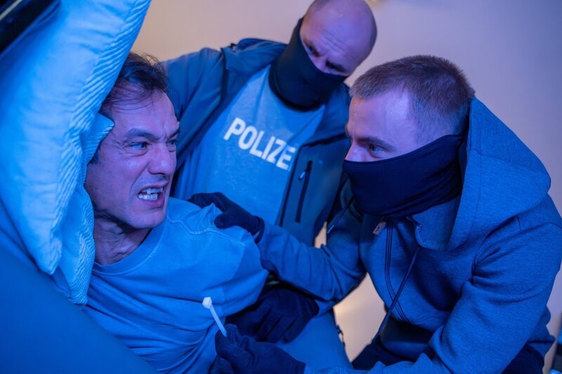 Ein Mann legt sich krank auf die Couch und schläft ein. Als er aufwacht, stehen zwei Räuber an seinem Bett. – Bild: ZDF und Saskia Pavek