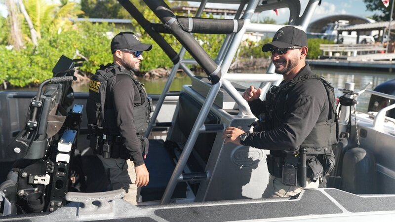 Mehrere AMO-Agenten sitzen auf einem Wasserfahrzeug und bereiten sich auf eine Suche auf dem Meer vor. – Bild: National Geographic