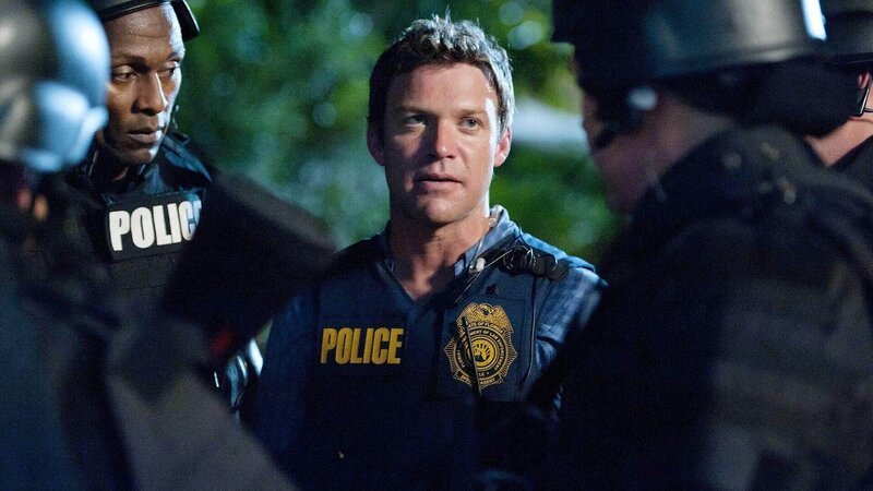 Jim (Matt Passmore, M.) bespricht mit den Cops den bevorstehenden Einsatz. – Bild: TVNOW