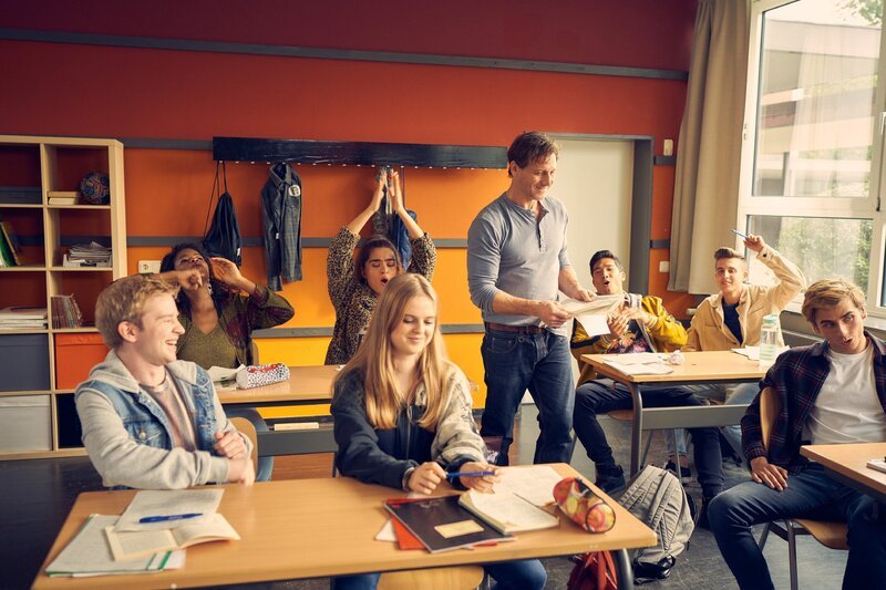 Andres (Jonah Rausch, l.) und der restliche G-Kurs ist von Bonnie (Stella Holzapfel, vorne) und ihrer schlagfertigen und direkten Art begeistert. Vollmer (Hendrik Duryn, stehend) ist überrascht. – Bild: RTL /​ Frank Dicks