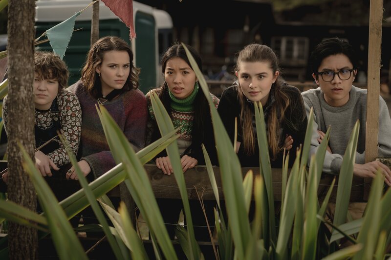 Auf dem Kauri Point Grillfest beobachtet die Reiterclique – von links: Stella (Harriet Walton), Issie (Macey Chipping), Caroline (Jacqueline Joe), Natascha (Antonia Robinson) und Caleb (Joshua Tan) – den Bürgermeister und die Reisejournalistin. Sie alle warten auf eine gute Gelegenheit den beiden klar zu machen, dass der Tourismus-Strom gestoppt werden muss. – Bild: ZDF/​Matt Klitscher