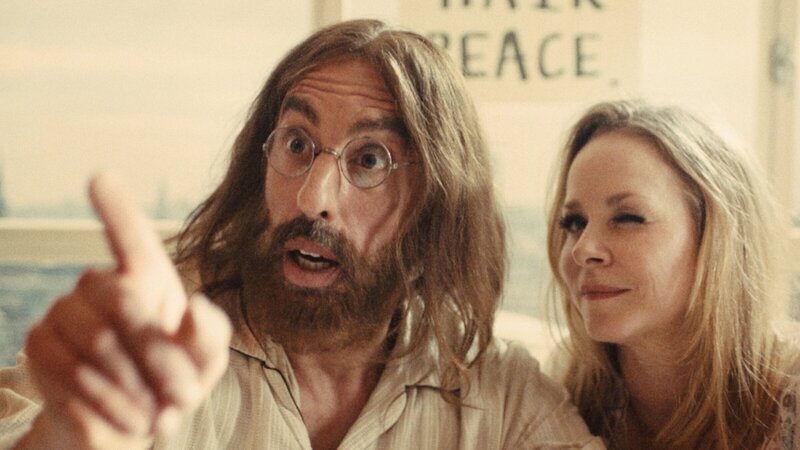 John Lennon (Alexander Schubert) hat einen Bad Hair Day. Bei seinem Bed-In kommt es zu einer unvorhergesehenen Wendung. Nicht seine Frau Yoko Ono liegt neben ihm im Bett, sondern ein holländisches Groupie (Jasmin Schwiers). – Bild: Tom Holzhauser