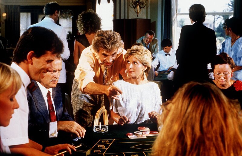 Thomas Graf Guldenburg (Wolf Roth, mi.) frönt wieder einmal seiner Spielleidenschaft und befindet sich auf der Verliererstraße. Da taucht Kitty (Susanne Uhlen) auf und schon wendet sich das Blatt. – Bild: ORF/​ZDF