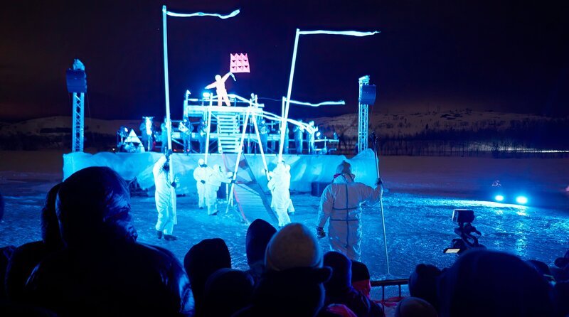 Im äußersten Norden Norwegens, dort wo Westeuropa und NATO an Russland grenzen, liegt Kirkenes – trotz seiner gerade mal 3500 Einwohner – ein geopolitisches Schwergewicht. Ein Grenzbataillon mit rund 700 Elitesoldaten und -soldatinnen zeigt in dem kleinen Frontstädtchen militärische Präsenz. Durch gezielte Kulturförderung demonstriert Norwegen hier seinen Macht- und Gebietsanspruch. – Die Eröffnungsshow des Barents-Spektakel erzählt von der möglichen Hoffnung auf Verständigung mit den russischen Nachbarn. Über 2000 der 3500 Einwohner von Kirkenes schauen zu. – Bild: rbb/​Jürgen Staiger