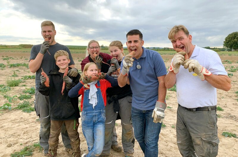 Andreas Gehrke (2.v.r.) mit der Familie Neutze aus dem nordhessischen Grebenstein. Die Neutzes sind Kartoffelbauern mit Leib und Seele und wagen dennoch Exotisches: Süße Kartoffeln aus Südamerika wachsen jetzt auch auf ihren Feldern. – Bild: HR/​Susanne Barfuß