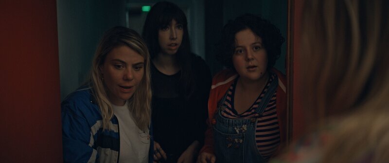 Mother Blocker (Sophie-Marie Larrouy, l.), Absinthe-ni-touche (Suzanne de Baeque, M.) und Marie-Josée (Salomé Diénis Meulien, r.) finden heraus, dass jemand absichtlich die Tür mit Holzplatten versperrt hat und sie somit in der Turnhalle eingesperrt hat. – Bild: Beta /​ ZDF