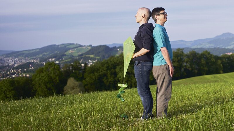 SRF DOK Kleine Männer – Klischees auf Augenhöhe Zwei kleine Männer messen sich auf dem Sonnenberg bei Kriens (LU). Steht Filmemacher Fabian Biasio auf der Bergseite, ist er gleich gross wie sein Protagonist Emanuel (168 cm). – Bild: SRF/​Biasio Produktion
