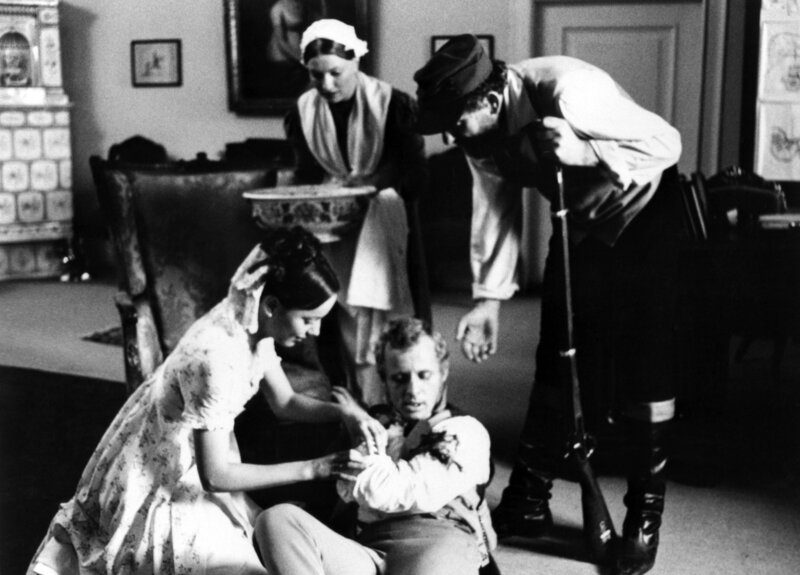 Ein Schuss hat sich gelöst beim Handgemenge zwischen Hawermann (Robert Zimmerling, rechts) und Axel von Rambow (Rolf Becker). Seine Frau Frieda (Marietta Schupp, vorn) und die Haushälterin Möllers (Uta Stammer) kümmern sich um den verletzten Gutsherrn. – Bild: NDR/​Hassenstein