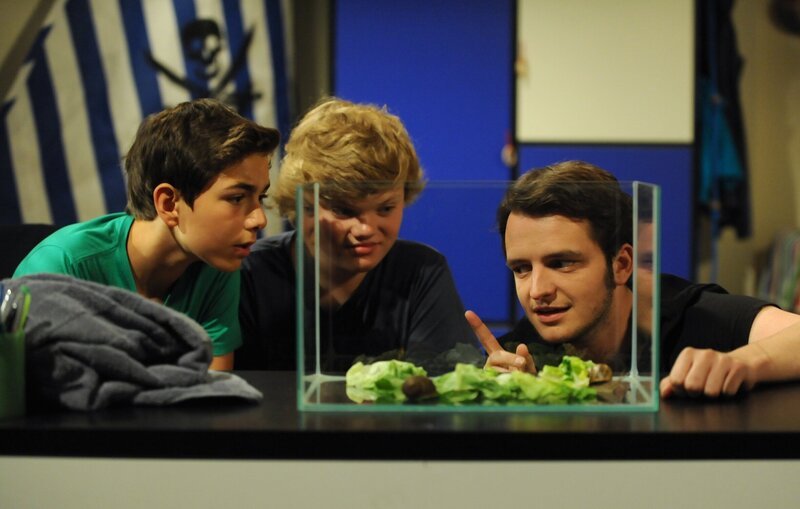 Felix und Philipp bitten Florian um Rat, wie sie die Schnecken dazu bringen, sich zu paaren. Von links: Felix Kramer (Shayan Hartmann), Philipp (Philip Schneider) und Florian Brunner (Tommy Schwimmer). – Bild: BR/​Marco Orlando Pichler