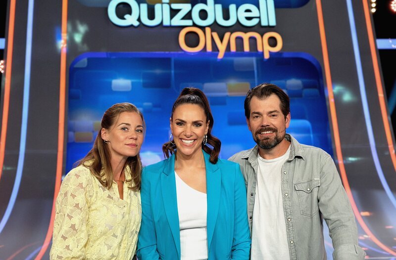 Moderatorin Esther Sedlaczek (M.) mit den Kandidaten des Teams „TVPAAR“: Jessica Ginkel (l.) und Daniel Fehlow (r.) – Bild: ARD/ITV Studios Moderatorin Esther Sedlaczek (M.) mit den Kandidaten des Teams „TVPAAR“: Jessica Ginkel (l.) und Daniel Fehlow (r.) – Bild: ARD/ITV Studios