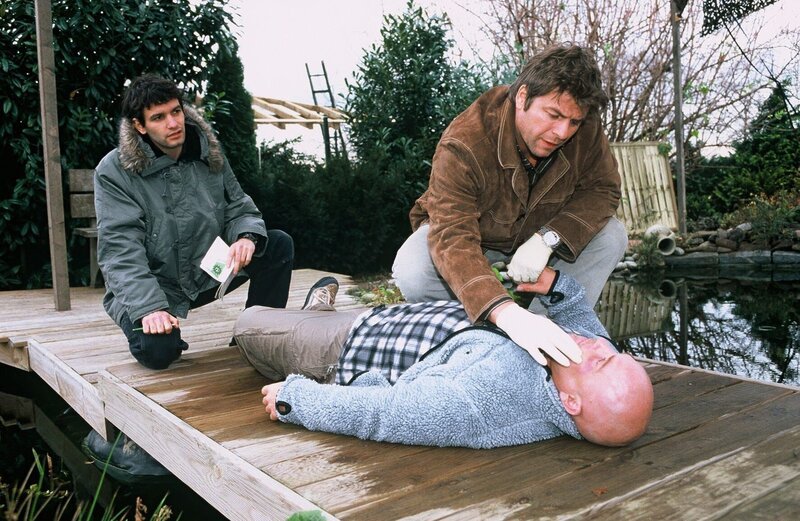 Jupp (Uwe Fellensiek, r.) und Gino (Luca Zamperoni, l.) untersuchen den toten Mitgudsch (Ingo Becker). – Bild: SAT.1 /​ Münstermann