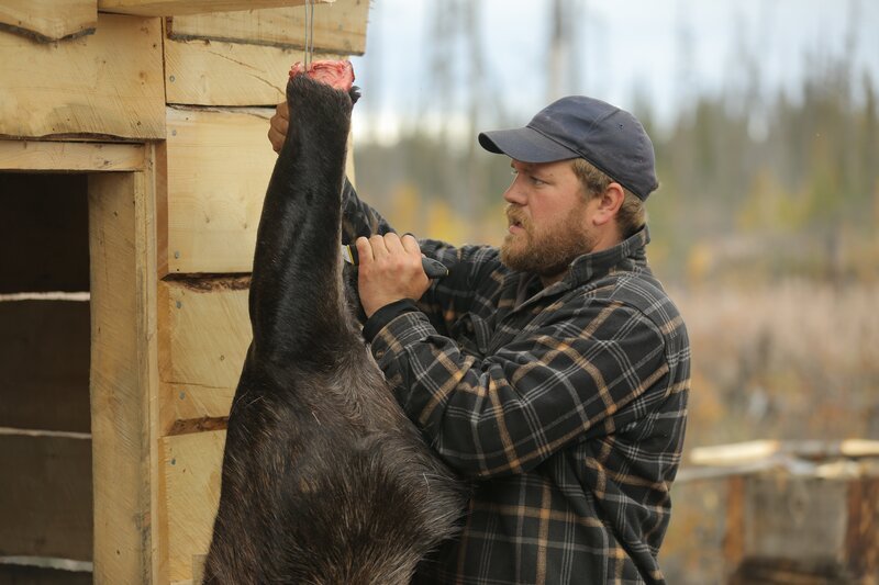 Dustin skinning a moose leg. – Bild: Discovery Communications