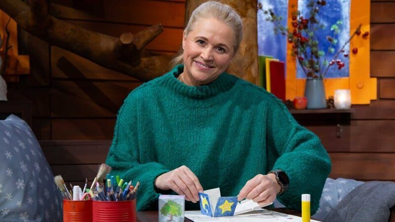 Singa klebt den MACH MIT!-Ruhewürfel zusammen, den sie vorher nochmal in blau und gelb abgemalt hat. – Bild: KiKA