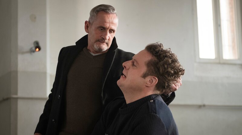 Petretti (Tim Wilde) nimmt den Wachmann (Christoph Bernhard) in die Mangel. – Bild: NDR/​Christine Schroeder