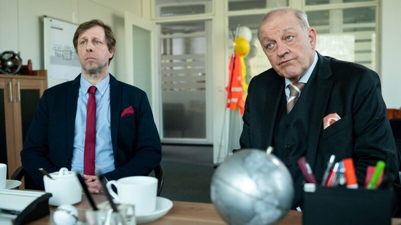 Privatdetektiv Wilsberg (Leonard Lansink, r.) und Ekki (Oliver Korittke, l.) geben sich als Inhaber eines Schweizer Immobilienfonds aus, um in einem Bauunternehmen zu ermitteln. – Bild: ZDF