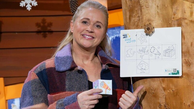 Singa bastelt den MACH MIT!-Ruhewürfel. Sie malt ihn bunt an und schneidet ihn aus. – Bild: KiKA