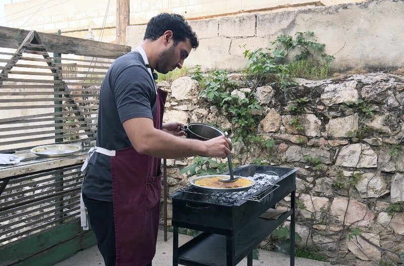Küchenchef Qais Malhas bereitet die palästinensische Variante von Kunafa zu und verrät ihr Geheimnis: die cremige Käsefüllung. – Bild: Elephant Doc