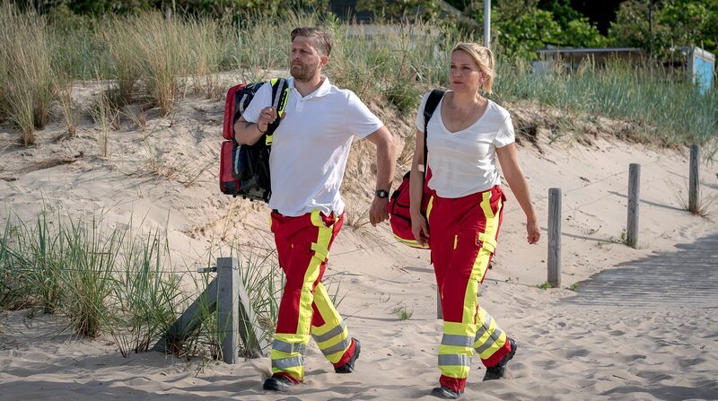 Einsatz am Strand: Nora Kaminski (Tanja Wedhorn, li.) mit ihrem Rettungssanitäter-Kollegen Lars Hinrichs (Bo Hansen). – Bild: ZDF und ARD Degeto/​Boris Laewen