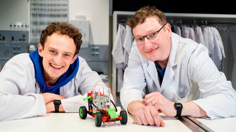 Welchen Kraftstoff Autos in Zukunft tanken könnten, erfährt Julian (links) von Chemiker Ronald. – Bild: BR/​megaherz gmbh/​Hans-Florian Hopfner