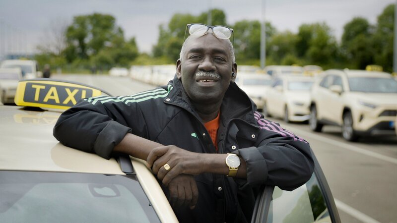 Cissé mit seinem Taxi. – Bild: Tobias Tempel /​ BR