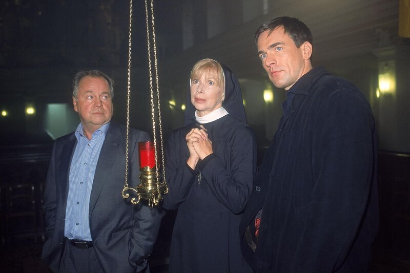 Auch die Haushälterin des ermordeten Pfarrers, Schwester Agnes (Ursela Monn), gehört zu den Verdächtigen. Die Beamten (li. Wolfgang Bathke, re. Wolfgang Krewe) befragen sie zu der Lebensweise des Mordopfers. – Bild: RTL /​ Rolf Baumgartner