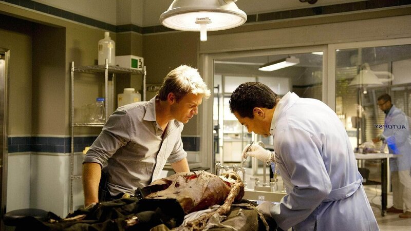 Carlos (Carlos Gomez, r.) hat die Leiche eingehend untersucht und erklärt Jim (Matt Passmore), was er rausgefunden hat. – Bild: TVNOW