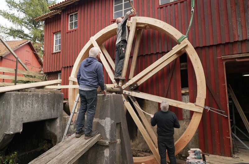 Die ehrenamtlichen Mühlradretter schieben das letzte von vier Felgensegmenten, an der Hundsberger Mühle im Schwäbischen Wald, zusammen. – Bild: SWR/​Dirk Schwarz