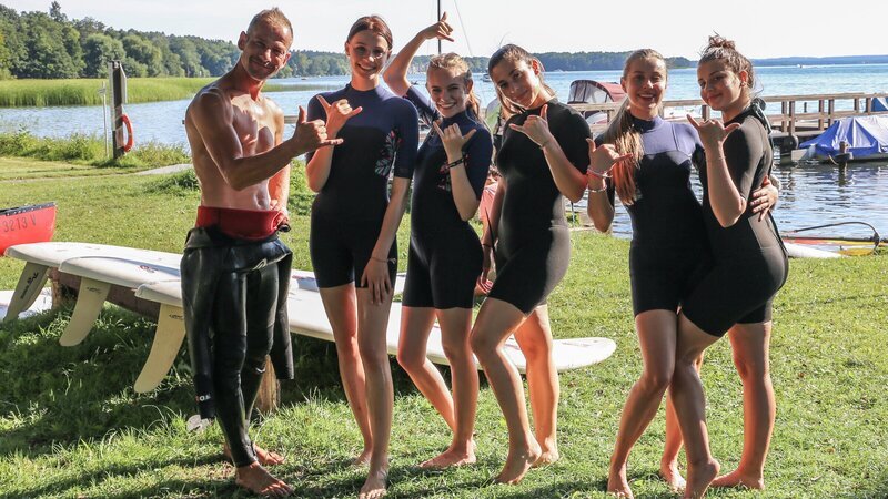 Surfzeit! Zusammen mit einem Surflehrer lernen die Mädchen wie sie auf den Brettern stehen bleiben. Von links: Surflehrer, Toni, Alexa, Feli, Luise und Anna – Bild: ZDF und e+u TV
