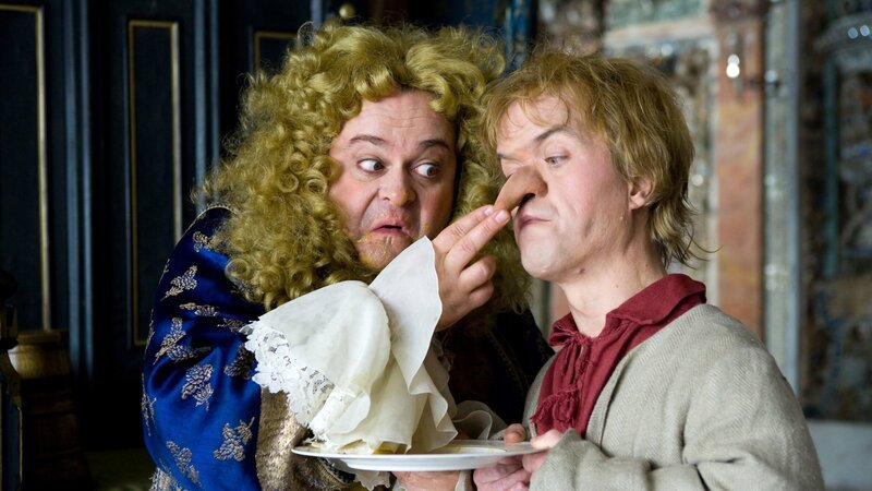 Als Zwerg Nase (Michael Markfort, rechts) dem bei Speisen höchst anspruchsvollen Herzog Alois (Markus Majowski) das Frühstück serviert, gibt ihm der Herzog einen Spitznamen: „Du bist ein Naseweis! Darum nenne ich dich von heute Zwerg Nase“. – Bild: ZDF und BR/​Hans-Peter Pfeil