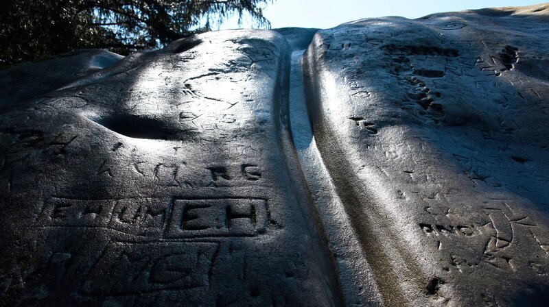 Rinne im Chindli-Stein. Auf ihr sollen früher Frauen mit unerfülltem Kinderwunsch gerutscht sein, so der Volksmund. Vermutlich diente die künstliche Rinnen zurr Opferung von Flüssigkeiten in der Steinzeit. – Bild: SWR