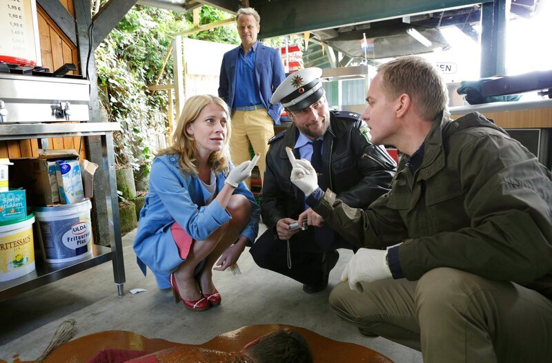 Der Frittenbudenbesitzer Jaap Mulders liegt tot in einer Lache aus „Saté-Saus“. Sophie Haas (Caroline Peters, l.), Parkbetreiber Huub van Uffelen (Reinout Bussemaker, 2.v.l. im HG), Dietmar Schäffer (Bjarne Mädel, 2.v.r.) und Dr. Bechermann (Patrick Heyn, r.) am Fundort der Leiche. – Bild: SWR/​ARD/​Michael Böhme