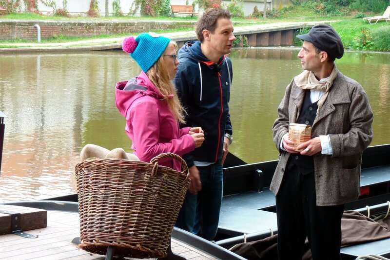 Die Reporter Esther Brandt (links) und André Gatzke (Mitte) sind unterwegs in Bremen: Im Findorffer Torfhafen zeigt Bootsführer Stefan (rechts), wie früher u.a. Kaffee geschmuggelt wurde. – Bild: WDR/​tvision