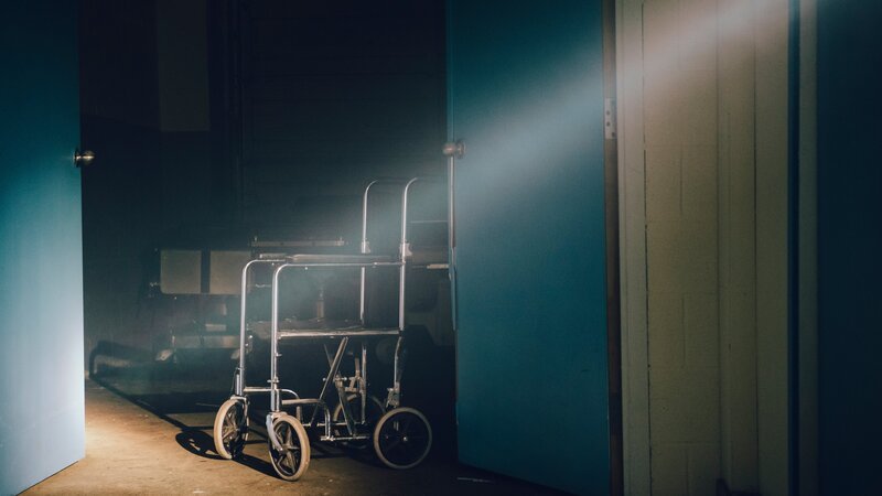 Krankenhausrollstuhl nachts auf einem Flur – Bild: Kew Media /​ Kew Media HH raw promo #8