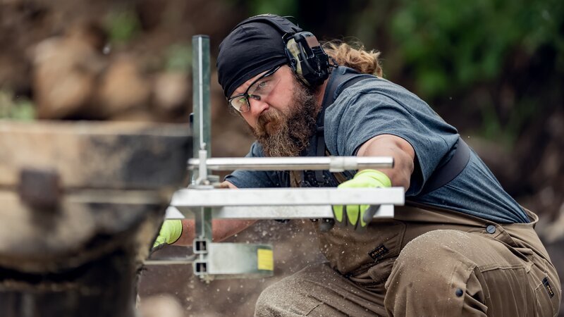 Justin Peterson sawing wood – Bild: Warner Bros. Discovery, Inc. or its subsidiaries and affiliates. All rights reserved.