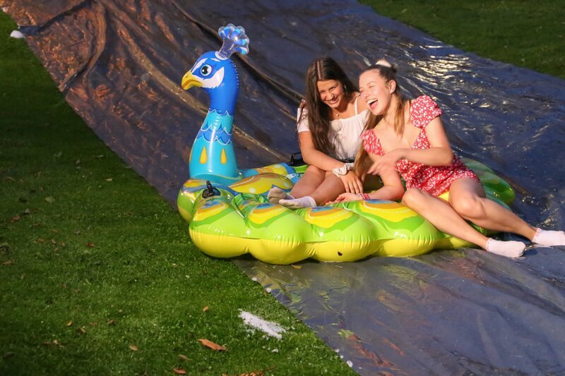 Anna (l.) und Luise (r.) lachen sich auf der Wasserrutsche kaputt. Die Abschiedsparty der WG-Mädels im Schlossgarten ist ein voller Erfolg. – Bild: e+u TV /​ ZDF