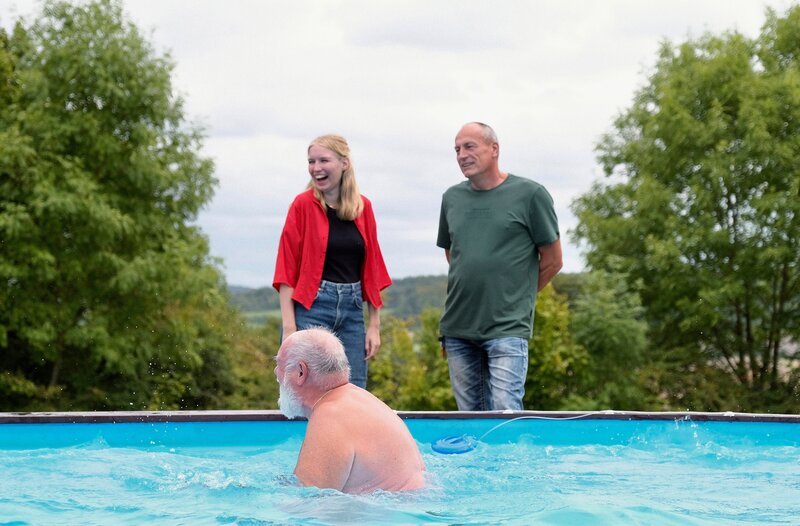 HESSISCHER RUNDFUNK Y-HISTORY: TABU NACKTHEIT – SIND WIR PRÜDER ALS UNSERE ELTERN? Wie bekommt man die jungen Leute in den Verein? Stefan Neuwirth (re.) vom FKK-Verein Oberhessen, im Gespräch mit Reporterin Lisa, weiß nicht weiter. – Bild: HR/​Marina Schnieders