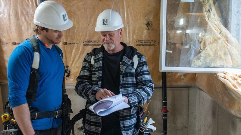 Michael Holmes (left) and Michael Holmes (right) review specs for the build of Patrick and Stokely’s basement as seen on Holmes Family Rescue, Season 2. – Bild: Warner Bros. Discovery, Inc. or its subsidiaries and affiliates