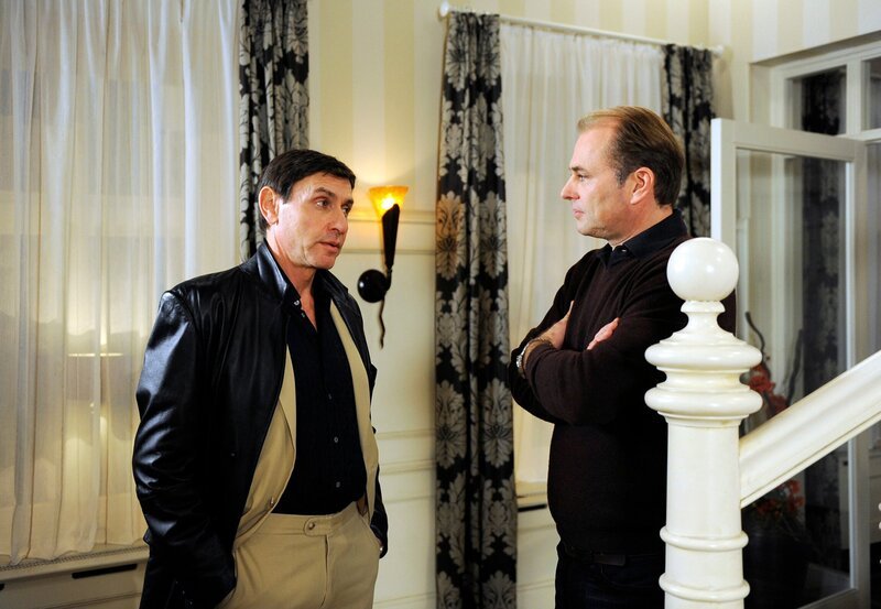 Malte (Marcus Bluhme, r.) verlangt mehr Geld von Petrov (Mark Zak, l.), weil der Cargo-Flug in das Kriegsgebiet, den er für ihn ausgeführt hat, illegal und lebensgefährlich war. – Bild: ARD/​Nicole Manthey