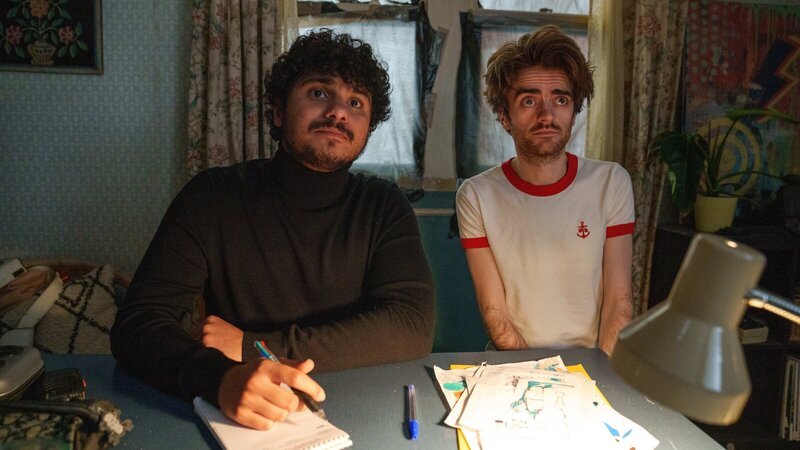 Mit Unterstützung von Jizzlord (Luke Rollason, r.) führt Kash (Bilal Hasna, l.) Bewerbungsgespräche für seine Bürgerwehr und trifft dabei auf äußerst skurrile Typen. – Bild: ZDF und Laura Radford/​Disney+