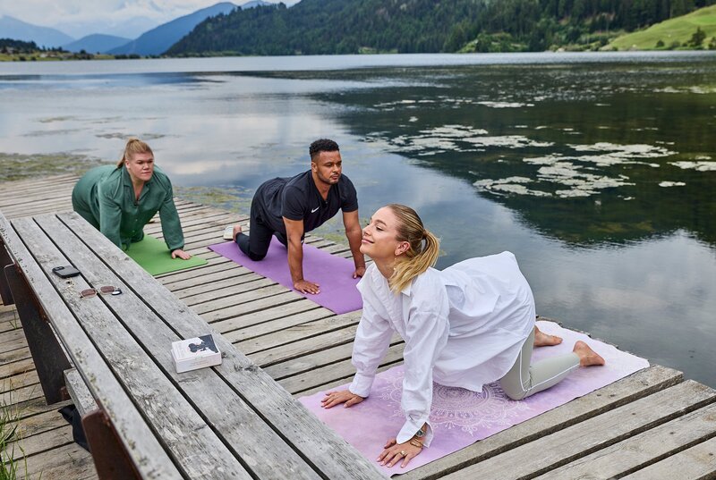 Lola teilt mit Gisa und Cossu ihre Morgenroutine: Yoga stehen auf dem Programm. – Bild: NDR/​Daniel Wolcke/​beckground tv