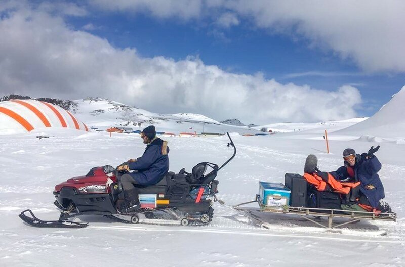 Ruben Günther und Lars Pfeiffer transportieren Forschungsequipment mit dem Skidoo. In der unerbittlichen Kälte von King George Island ist jede Arbeit mühselig. – Bild: Joanna Michna