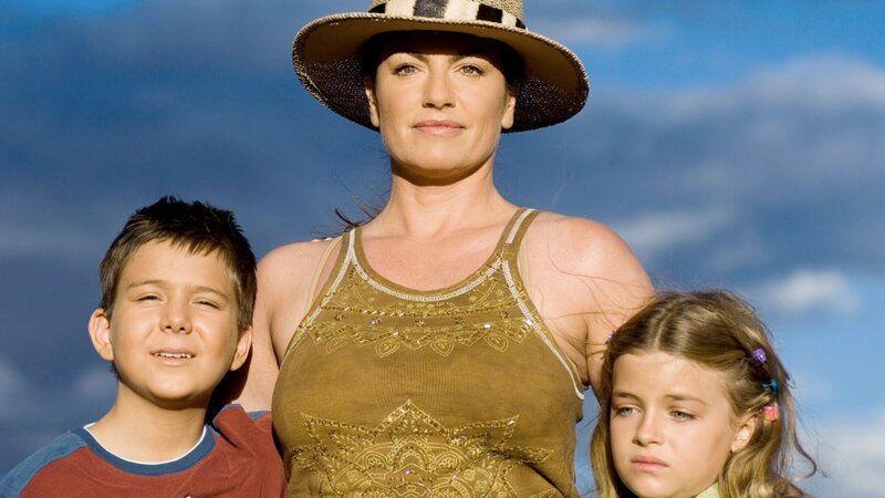 Katrin (Christine Neubauer, Mitte) kümmert sich um Neo (Pascal Andres) und seine kleine Schwester Lindiwe (Ronja Forcher), die nach dem Tod ihres Vaters Vollwaisen sind. – Bild: ZDF und ARD Degeto/​Thomas Schumann