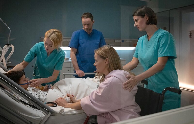 Gemeinsam mit seiner Mutter Nelly Herzog (Jessica Ginkel, 2.v.re.) versuchen die Ärzte den kleinen Anton (Lucano Resta, li.) aufwachen zu lassen. Doch plötzlich wird er tachycard. Ärzte v.li.: Dr. Katharina Schulte (Isabell Gerschke), Dr. Kai Hoffmann (Julian Weigend), Dr. Maria Weber (Annett Renneberg) – Bild: MDR/​Saxonia Media/​Rudolf Wernicke