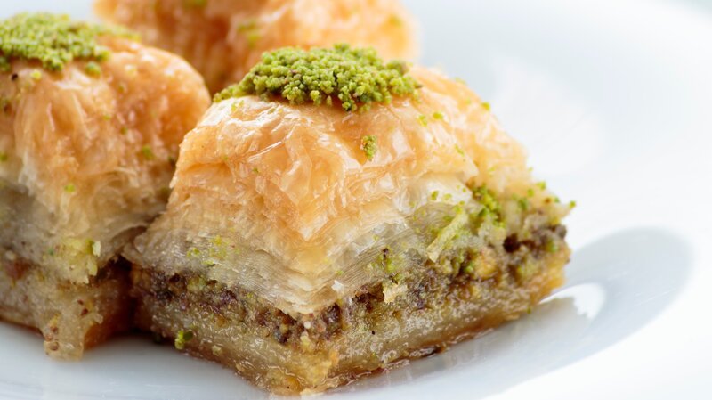 Baklava with pistachios and walnuts on white plate. Shallow depth of field – Bild: DarioZg