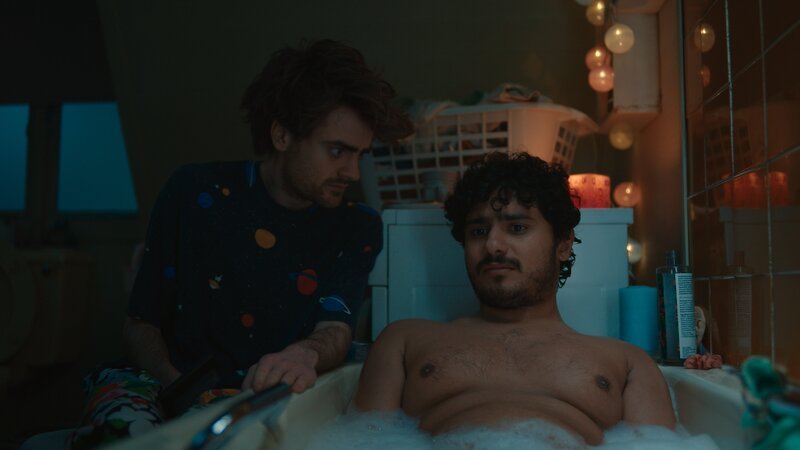 Um Kash (Bilal Hasna, r.) nach seinem missglückten Bürgerwehr-Einsatz aufzumuntern, greift Jizzlord (Luke Rollason, l.) zu skurrilen Methoden, die er aus seinem früheren Leben als Katze kennt. – Bild: The Walt Disney Company Limite /​ ZDF