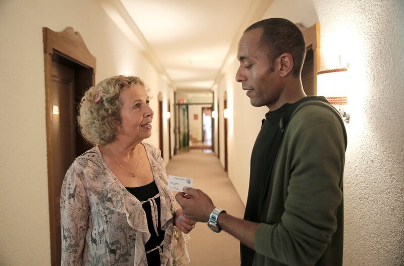 Kommissar Jerry Paulsen (Peter Marton, r.) gibt der Altenheimbewohnerin Rita Fischer (Michaela May, l.) seine Visitenkarte – man weiß ja nie, wann man sie braucht. – Bild: ARD/​Lucky Bird Pictures/​Christoph Krauth
