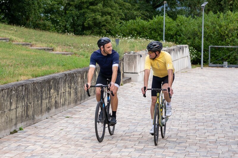 Psychologe Leon Windscheid (l.) und der ehemalige Radrennprofi Jan Ullrich (r.) auf einer gemeinsamen Fahrradtour. – Bild: ZDF und Marius Fuchtmann